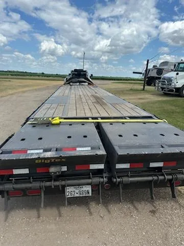 Rear view of an empty flatbed trailer with loading deck extending forward