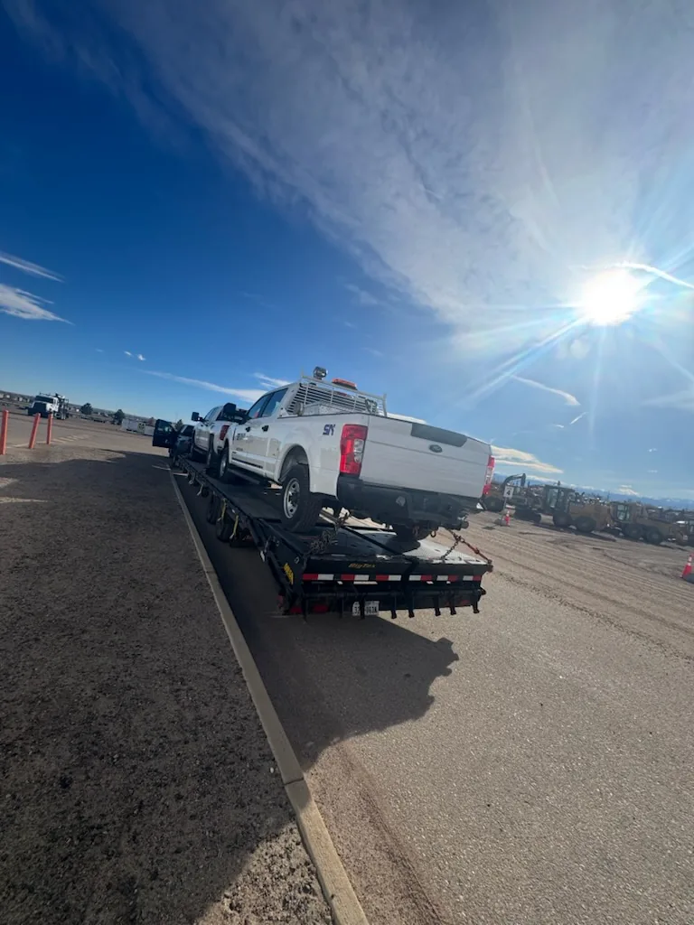 Flatbed trailer photographed from a low rear-quarter angle in an open yard