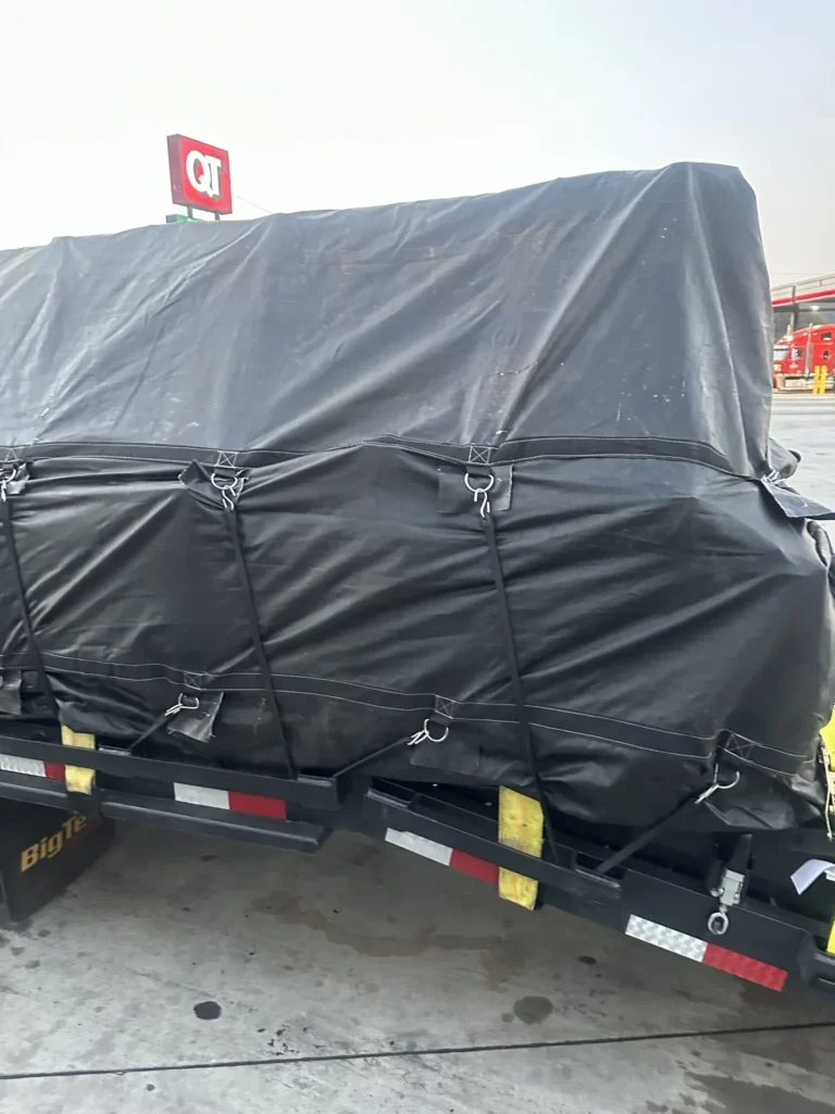 Covered load shown from the rear quarter with fitted tarp and trailer markings