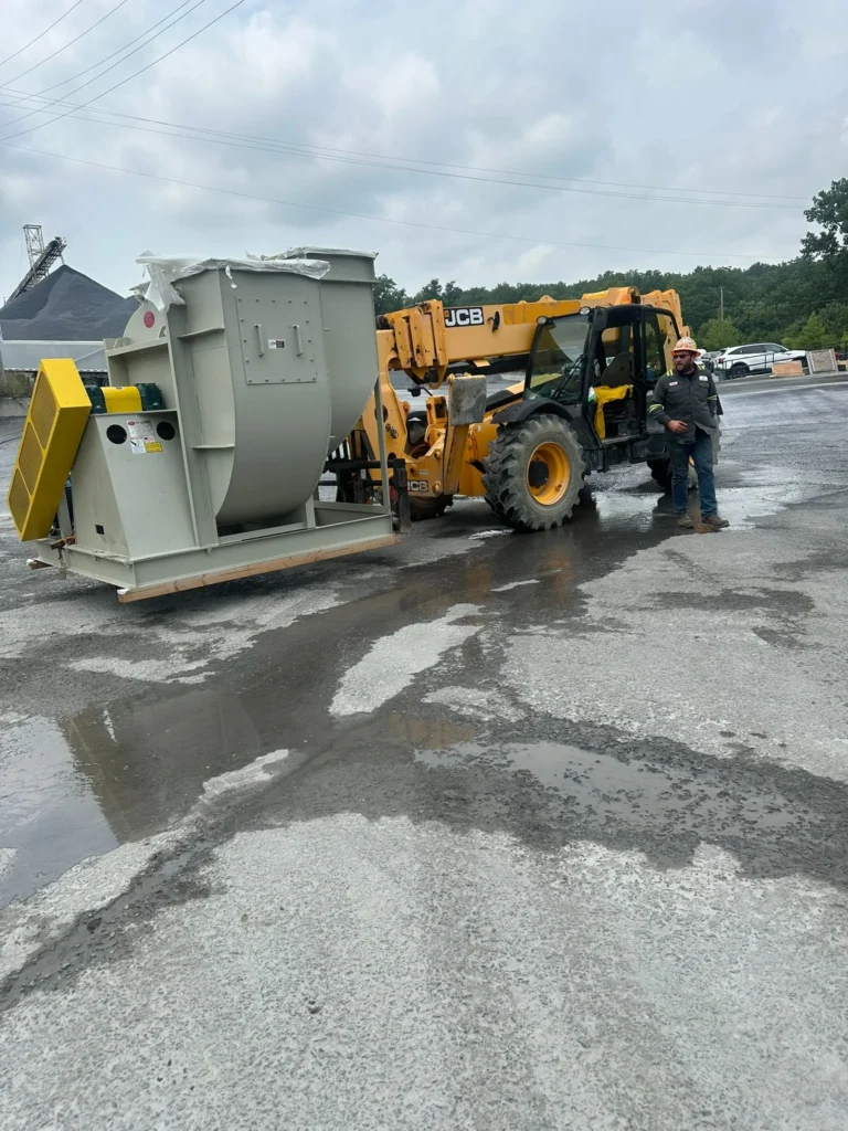 Industrial blower assembly shown during equipment positioning with a telehandler