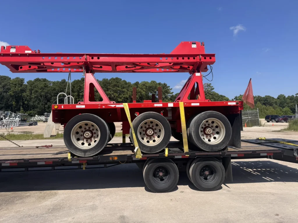 Red specialized machine centered on a flatbed deck with open loading area visible
